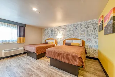 a hotel room with two beds and a mural at La Mirage Inn - Hollywood in Los Angeles