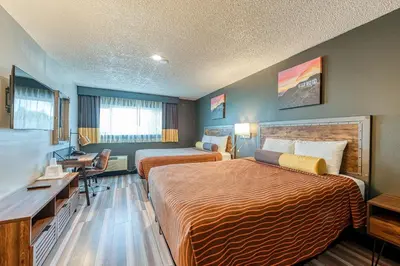 a hotel room with two beds and a desk at La Mirage Inn - Hollywood in Los Angeles