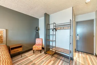 a bedroom with a bunk bed and a chair at La Mirage Inn - Hollywood in Los Angeles