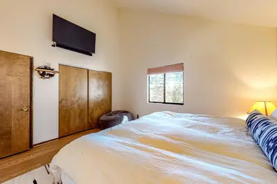 a bedroom with a large bed with a tv on the wall at Grey Stone Fire in Running Springs