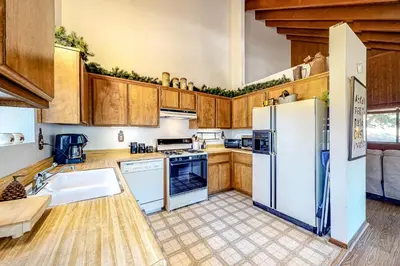 a kitchen with white appliances and wooden cabinets at Grey Stone Fire in Running Springs