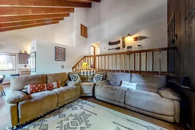 a living room with a large couch and a staircase at Grey Stone Fire in Running Springs