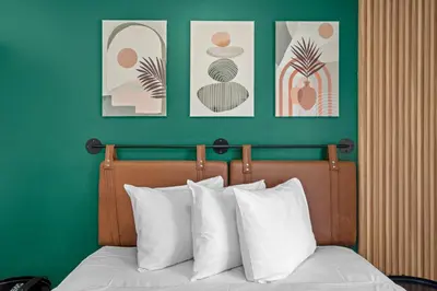 a bedroom with a bed with three pictures on the wall at Hollywood Le Bon Hotel in Los Angeles