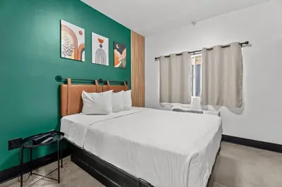 a bedroom with a large bed with a green wall at Hollywood Le Bon Hotel in Los Angeles