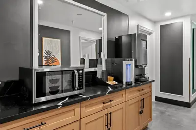a kitchen with a microwave and a black counter top at Hollywood Le Bon Hotel in Los Angeles