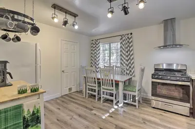 a kitchen with a table and chairs and a stove at Cozy Cabin about 3 Mi to Lake Arrowhead Village! in Lake Arrowhead