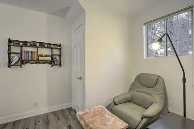 a living room with a chair and a lamp at Cozy Cabin about 3 Mi to Lake Arrowhead Village! in Lake Arrowhead