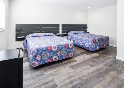 two beds sitting in a room with at Holly Park Motel near LAX in Inglewood