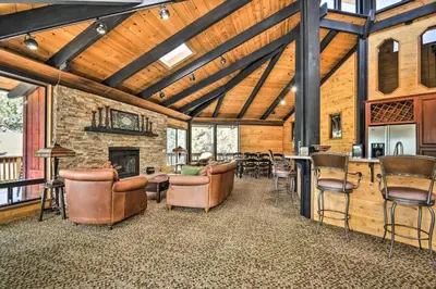 a living room with leather chairs and a fireplace at Cozy Grand Woodland Cabin with Mountain Views in Pine Mountain Club