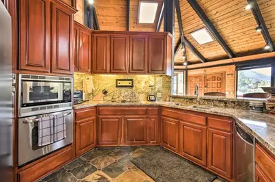 a large kitchen with wooden cabinets and appliances at Cozy Grand Woodland Cabin with Mountain Views in Pine Mountain Club