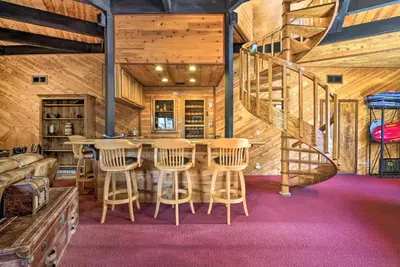 a log cabin with a table and chairs and a spiral staircase at Cozy Grand Woodland Cabin with Mountain Views in Pine Mountain Club