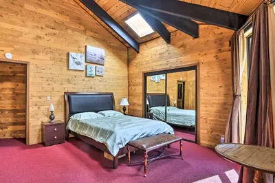 a bedroom with a bed and a table at Cozy Grand Woodland Cabin with Mountain Views in Pine Mountain Club