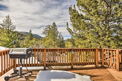 a grill on the deck of a house at Cozy Grand Woodland Cabin with Mountain Views in Pine Mountain Club