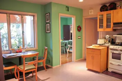a kitchen with green walls and a table and chairs at Bixby Beauty 50s Mod Long Beach in Long Beach