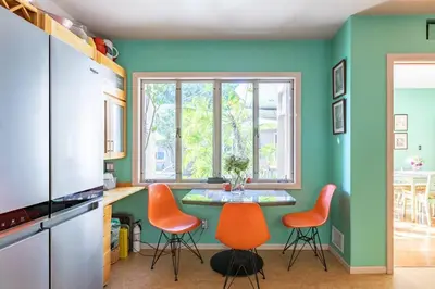 a kitchen with orange chairs and a small table at Bixby Beauty 50s Mod Long Beach in Long Beach