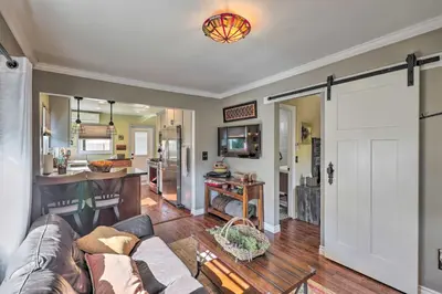a living room with a couch and a kitchen at Charming Craftsman Bungalow with Garden and Hot Tub! in Fullerton