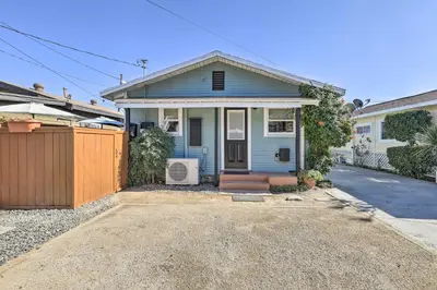a blue house with a fence in front of it at Charming Craftsman Bungalow with Garden and Hot Tub! in Fullerton