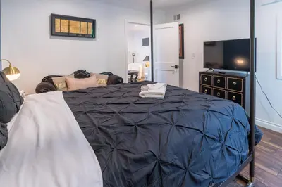 a bedroom with a large bed and a television at Le Bleu House - Newly Designed 3BR HOUSE & POOL by Topanga in Los Angeles