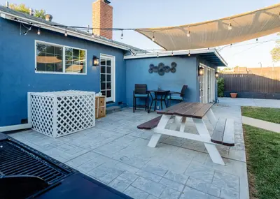 a patio with a picnic table and a blue house at Le Bleu House - Newly Designed 3BR HOUSE & POOL by Topanga in Los Angeles