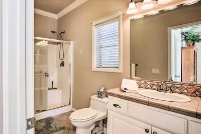 a bathroom with a toilet and a sink and a mirror at Huge Lake Arrowhead Home with 3 Decks and Grill! in Lake Arrowhead
