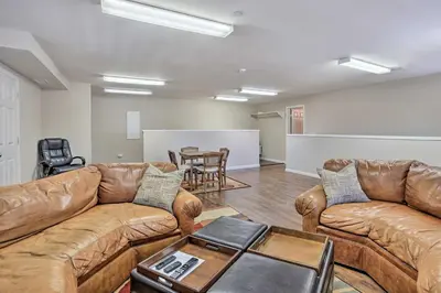 a living room with leather couches and a table at Huge Lake Arrowhead Home with 3 Decks and Grill! in Lake Arrowhead