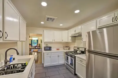 a kitchen with white cabinets and a stainless steel refrigerator at Riverside House with Yard about 1 Mi to Downtown! in Riverside