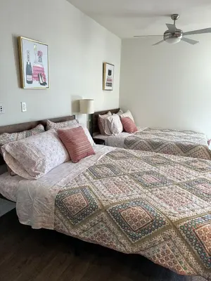 a bedroom with two beds and a fan at Incredible Hollywood Loft Free Parking in Los Angeles