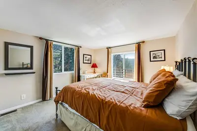 a bedroom with a bed and a large window at Gregory Getaway in Crestline