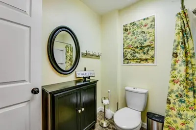 a bathroom with a toilet and a mirror at Gregory Getaway in Crestline