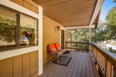 a porch of a house with a chair on it at Gregory Getaway in Crestline