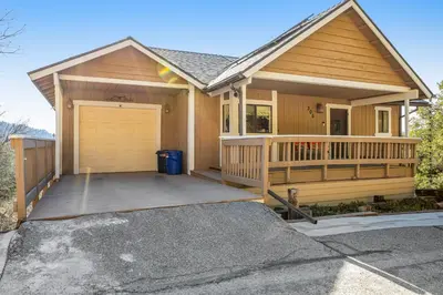 a house with a large porch and a garage at Gregory Getaway in Crestline
