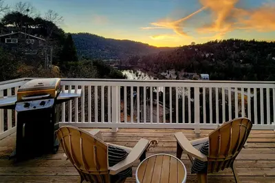 a grill and chairs on a deck with a view at Gregory Getaway in Crestline