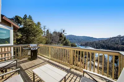 a deck with chairs and a view of the water at Gregory Getaway in Crestline