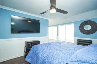 a blue bedroom with a bed and a flat screen tv at Valencia CA Stunning 3100 +sqft, 5Bed/5Bath home in Santa Clarita