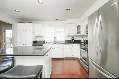 a kitchen with white cabinets and a stainless steel refrigerator at Valencia CA Stunning 3100 +sqft, 5Bed/5Bath home in Santa Clarita