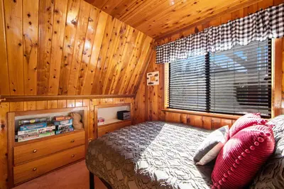 a bedroom with a bed and a window in a cabin at The Valley's Cabin in Green Valley Lake