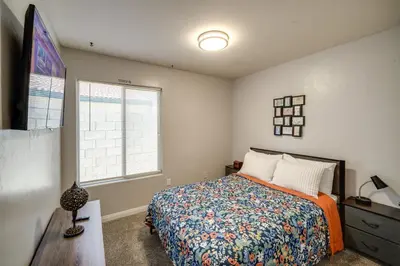 a bedroom with a bed and a dresser and a window at Private Pool and Patio Pet-Friendly Bakersfield Gem in Bakersfield