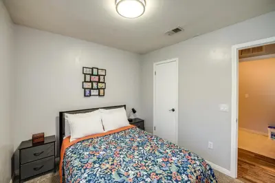 a bedroom with a bed and a dresser and a door at Private Pool and Patio Pet-Friendly Bakersfield Gem in Bakersfield