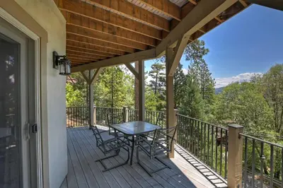 a patio with a table and chairs on a deck at Beautiful Lake Arrowhead Cabin with EV Charger in Lake Arrowhead