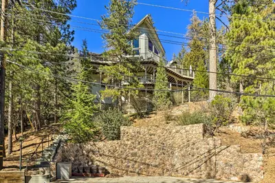 a house on a hill with stairs and trees at Beautiful Lake Arrowhead Cabin with EV Charger in Lake Arrowhead