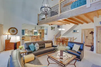 a living room with a couch and a table at Beautiful Lake Arrowhead Cabin with EV Charger in Lake Arrowhead