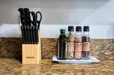 two knives and bottles of spices on a counter at Dreamy & Relaxing Gem With Backyard - 12mins to DT LA in Alhambra