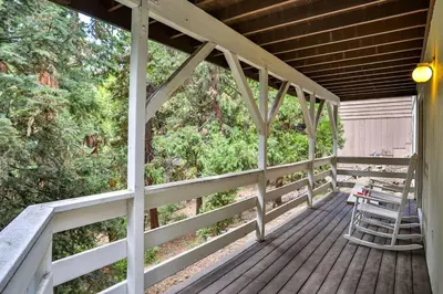 a porch of a house with a bench and trees at Lake house Cabin - Lake Arrowhead in Lake Arrowhead