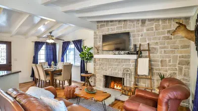 a living room with a stone fireplace and leather furniture at Lake house Cabin - Lake Arrowhead in Lake Arrowhead
