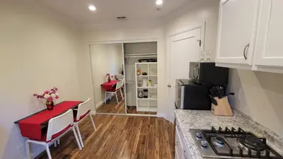 a kitchen with a counter top and a red table at Adorable modern guesthouse with full kitchen in Encino