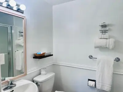 a bathroom with a toilet and a sink and a mirror at Foghorn Harbor Inn in Los Angeles