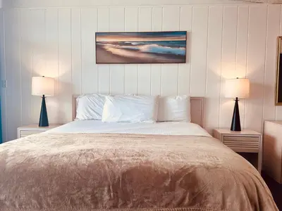 a bedroom with a large bed with two lamps at Foghorn Harbor Inn in Los Angeles