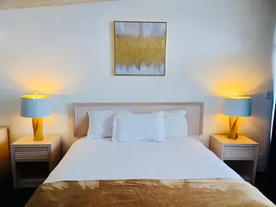 a bedroom with a bed with two lamps on both sides at Foghorn Harbor Inn in Los Angeles