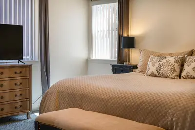 a bedroom with a bed and a dresser with a television at Lazy Squirrel - Cozy Family House with Full Game Room in Kernville