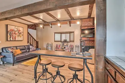 a kitchen and living room with a table and stools at Woodsy Twin Peaks Getaway with Hot Tub and Views! in Twin Peaks